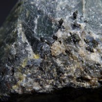 Blue sodalite (Na,K)AlSiO4, yellow cancrinite (Na,Ca,☐)8(Al6Si6O24)(CO3,SO4)2·2H2O and black pyroxene – aegirine NaFeSi2O6 in nepheline (Na,K)AlSiO4 pegmatie; Donskoy quarry, Mazurovskoe Zr deposit, Oktyabr'skii Massif (Mariupol'skii), Azov Sea Region, Donetsk (Donets'k) Oblast', Ukraine; FOV: 36 mm