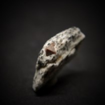 Octahedral crystal of zircon Zr(SiO4); Donskoy quarry, Mazurovskoe Zr deposit, Oktyabr'skii Massif (Mariupol'skii), Azov Sea Region, Donetsk (Donets'k) Oblast', Ukraine; crystal about 5 mm