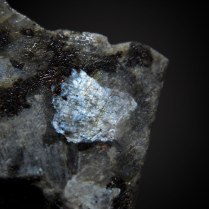 Plagioclase var. labradorite (Ca,Na)[Al(Al,Si)Si2O8] with blue labradorescence in gabbro/anorthosite; Wolibórz (Volpersdorf), Kłodzko District, Lower Silesia (Dolnośląskie), Poland; crystal 6 x 5 mm